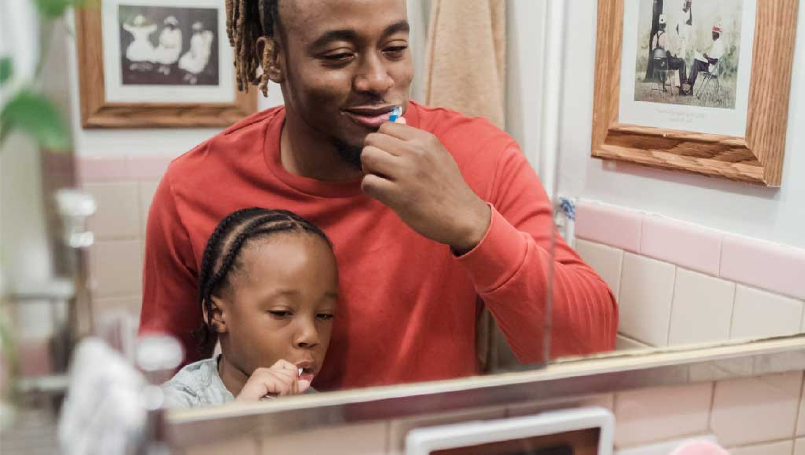 Man and child brushing teeth