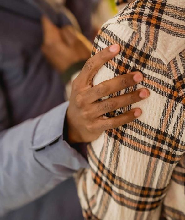 A picture of a hand on a shoulder referring a support