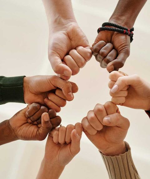 Group of 7 people fist bumping referring to support